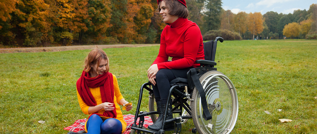 Fotografia przedstawiw osobęniepełnosprawną na wózku wraz z towrzyszącą jej osobą